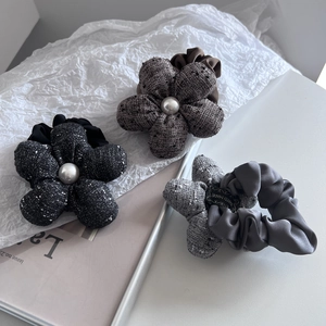 Three-piece set of elegant tweed flower hair ties with pearl centers in black, brown, and gray