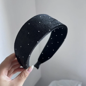 Close-up of elegant black velvet headband featuring silver metallic rivet studs and inner teeth