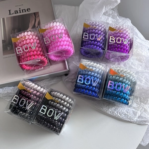 Detail view of five gradient spiral hair ties in transparent PVC gift packaging