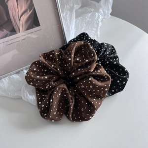 Détail de chouchous en satin avec strass dans les tons noir et marron café élégants