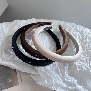 Detail of four velvet headbands with pearls in black, brown, champagne and grey colors