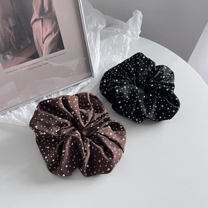 Détail de chouchous en satin avec strass argentés de couleur marron foncé et noir
