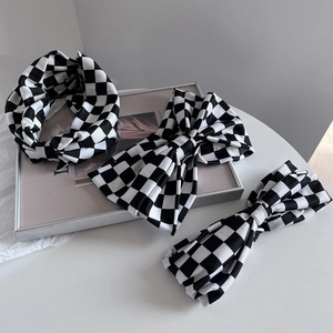 Set aus klassischem schwarz-weißem Schachbrett-Strickstirnband, Haarspange und Haargummi