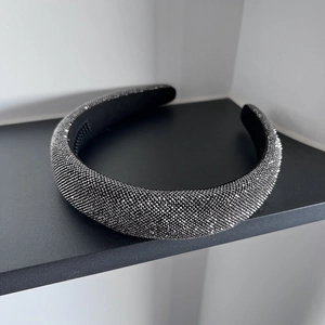 Close-up of sparkling dark grey rhinestones on a black headband with anti-slip teeth