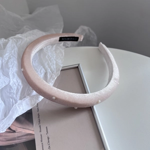 Detailed macro view of handmade pink velvet headband with elegant white pearls decoration