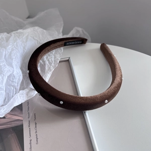 Detailed macro view of handmade brown velvet headband with delicate pearl embellishments