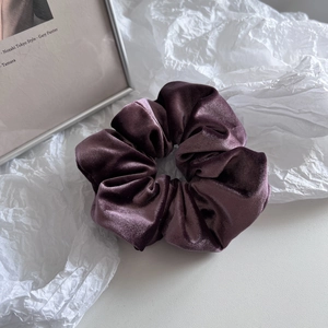 Detail of dark purple velvet scrunchie showing soft texture and rich metallic luster