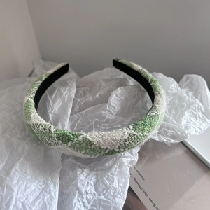 Detail view of the green and white plaid tweed headband with non-slip black lining