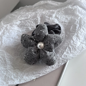 Detail of tweed fabric flower hair tie with pearl center and satin elastic band