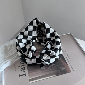 Detaillierte Makroansicht der Strickstruktur eines schwarz-weiß karierten Stirnbands
