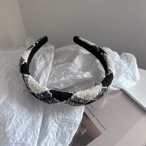 Detailed close-up of black and white tweed headband with gold lurex and soft textures