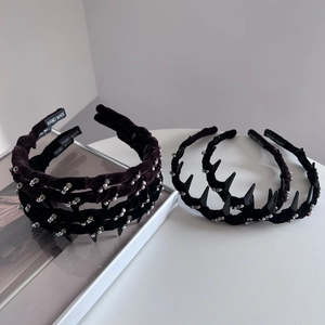 Detailed macro view of black velvet headbands featuring silver rhinestones and gothic spikes