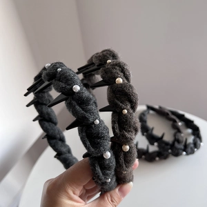 Detailed view of hand-sewn pearls and knit texture on luxury wool headband hair accessories