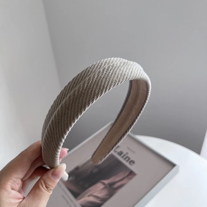 Detailansicht eines beigen Strickstirnbands mit Webstruktur und Antirutschfutter