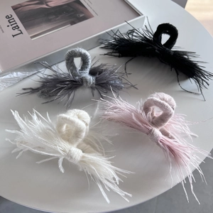 Detail of wool knit claw clips with soft ostrich feathers in four elegant colors