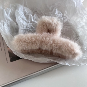 Vue détaillée d'une grande pince à cheveux en peluche rose nude avec texture fausse fourrure