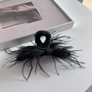 Detailed view of elegant black ostrich feather hair claw clip with knit texture finish