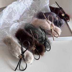 Détail de pinces à cheveux en peluche de plusieurs couleurs avec nœuds et pendentifs dorés