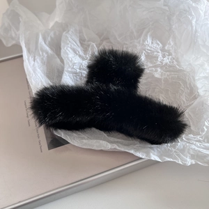 Détail de la pince à cheveux noire en peluche avec texture douce en fausse fourrure