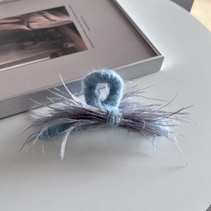 Detailed view of light blue plush hair claw clip with elegant grey-purple ostrich feathers