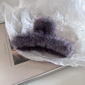 Détail d'une pince à cheveux en peluche violette avec texture douce pour l'automne-hiver