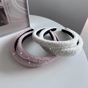 Detail of plush sequined headbands in pink and white with soft faux fur texture