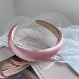 Détail d'un serre-tête en satin rose avec texture élégante et doublure intérieure antidérapante