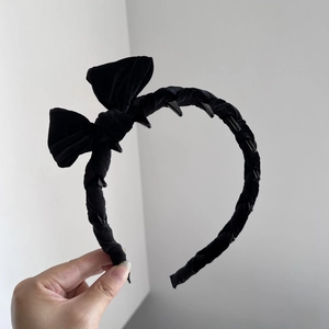 Detail view of black velvet bow headband featuring plastic non-slip inner teeth