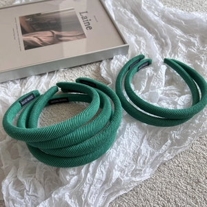 Vue détaillée du serre-tête en tissu côtelé vert avec étiquette intérieure et rembourrage