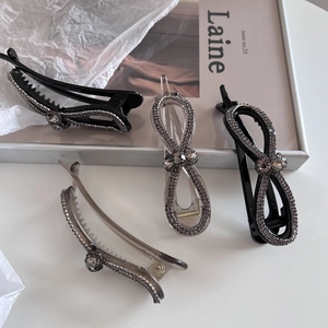 Pince à cheveux noeud torsadé élégante avec strass gris brillants au design moderne