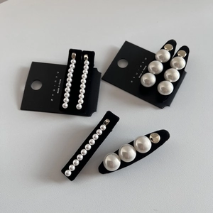 Détails des barrettes à perles blanches sur base dorée avec doublure en velours noir
