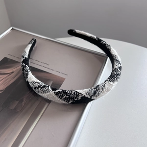 Close-up of black and white plaid tweed headband with metallic gold silk thread detail