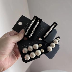 Détail du lot de barrettes à perles blanches lisses de différentes tailles sur carte de support