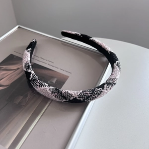 Detailed view of woven plaid headband with shimmering threads and thick sponge padding