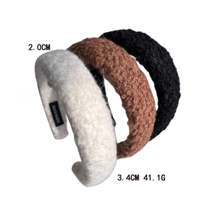 Detail showing 3.4cm wide sponge wool headband dimensions and handmade label