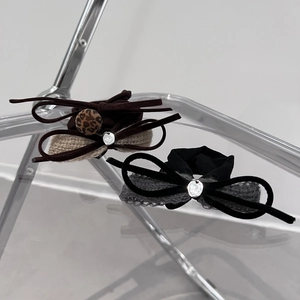Brown and black velvet bow hair scrunchies with leopard accent on minimalist chair