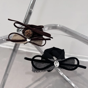 Elegant bow hair ties in dark brown leopard and black knit style on minimalist display