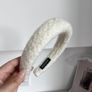 Detailed macro shot of thick cream teddy fleece headband showing the handmade label