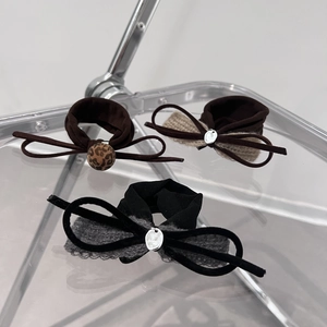 Three-piece set of velvet bow hair ties in dark brown and black with leopard bead accents