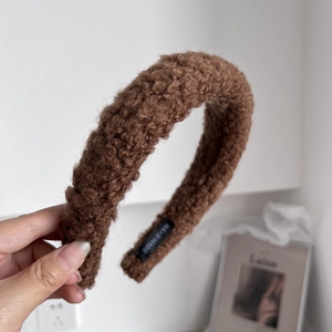 Detailed close-up of brown wool plush headband featuring a hand made woven label