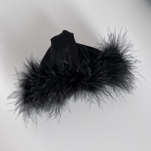 Close-up of black velvet hair claw with soft ostrich feather details and plush texture
