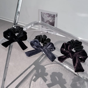 Detail view of velvet bow hair ties in black, grey blue and vintage coffee colors