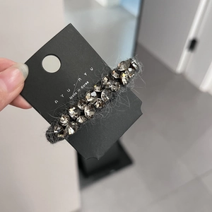 Détail d'une pince à cheveux de luxe avec cristaux gris et tissu pelucheux