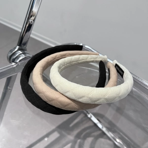 Detail of quilted sponge headbands in black and beige with handmade woven label detail