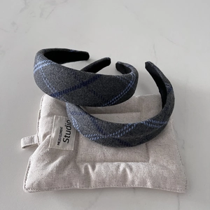 Detail of grey wool headband with blue plaid texture and non-slip lining