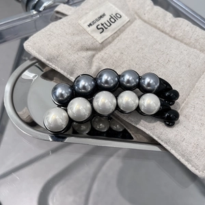 Barrettes banane élégantes avec perles grises et ivoire sur un plateau en métal