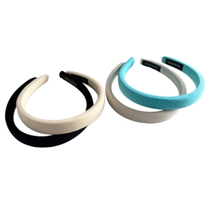 Four colorful padded sponge headbands in cream tones featuring textured knit fabric finish