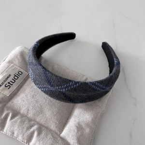 Close-up of grey and blue plaid wool fabric headband with non-slip black inner lining