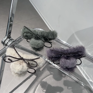 Vista dettagliata di tre fermagli per capelli in peluche nei colori grigio, lavanda e beige