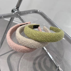 Three padded sponge headbands in pink, beige, and green with woven texture for hair